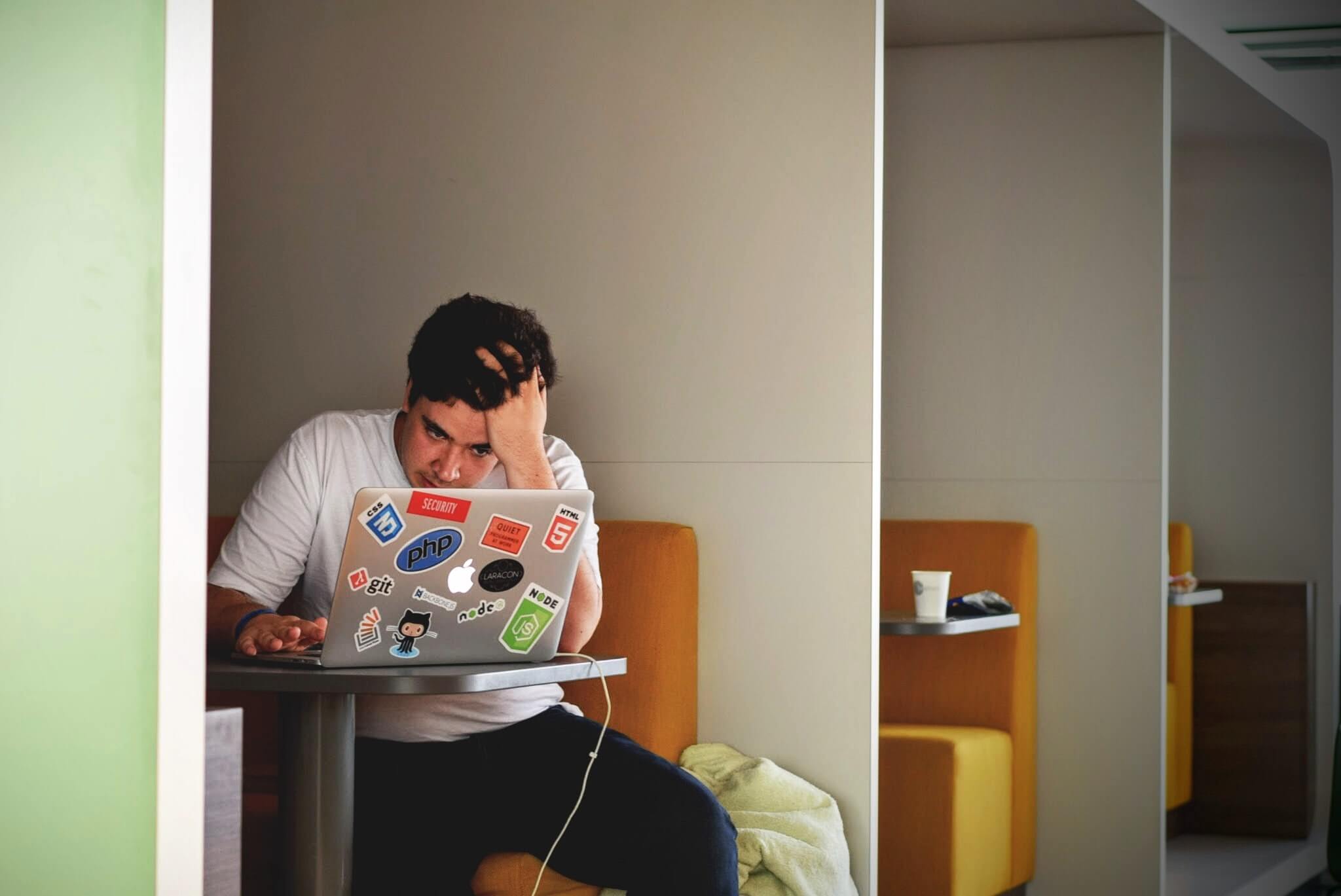 Person feeling stressed while working on a computer, representing the challenges of managing workload and stress in a digital workspace.