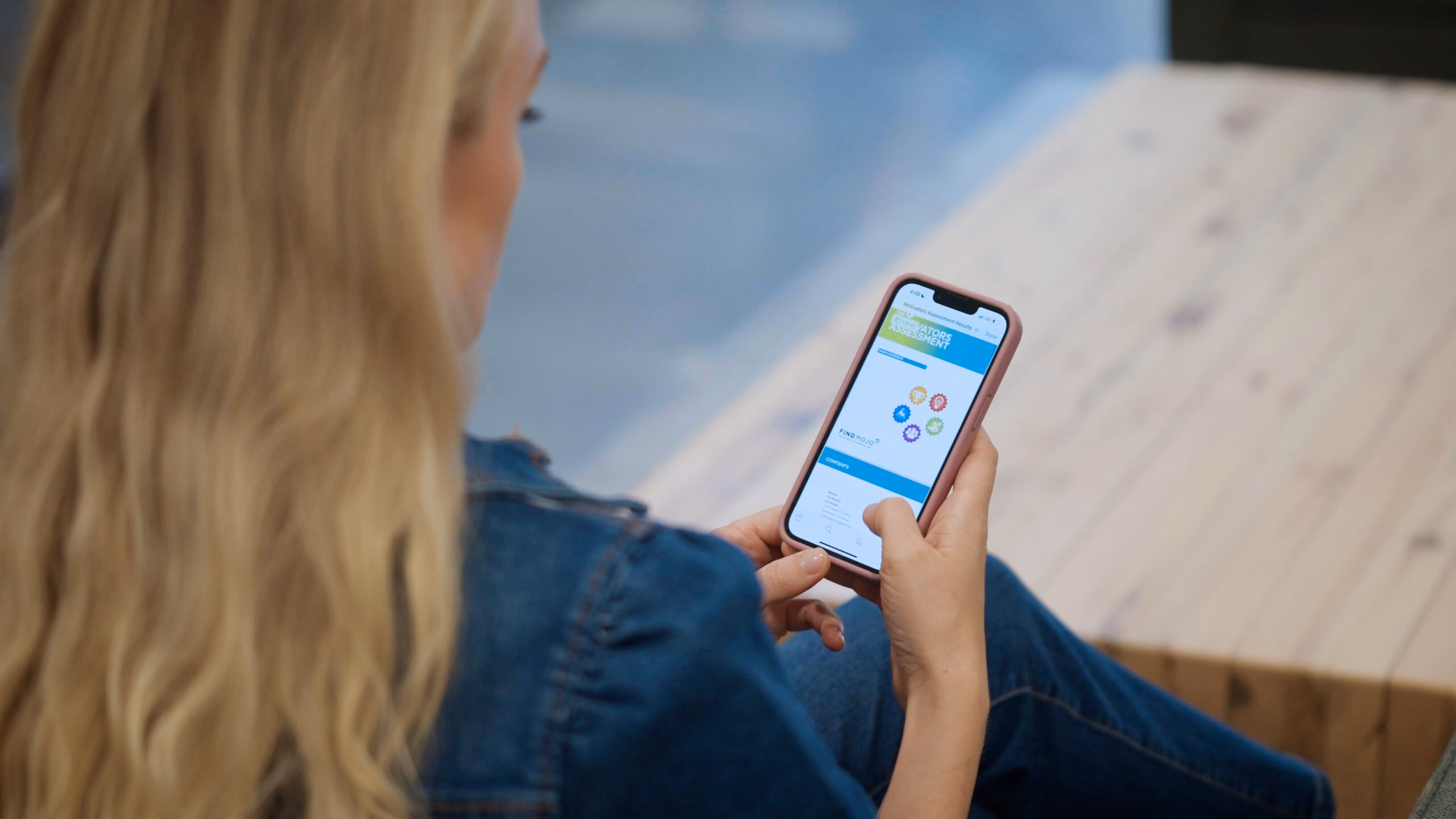 Woman on phone viewing her FindMojo motivation assessment results, symbolizing self-discovery, personal growth, and career development.
