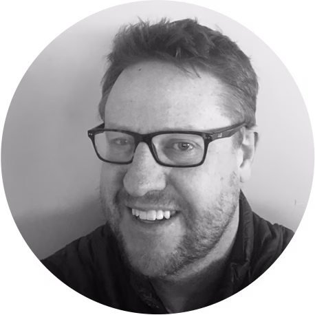 Profile of a businessman in glasses smiling.