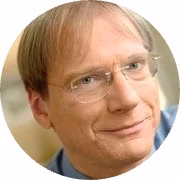 Profile of a professional man with blonde hair and glasses.
